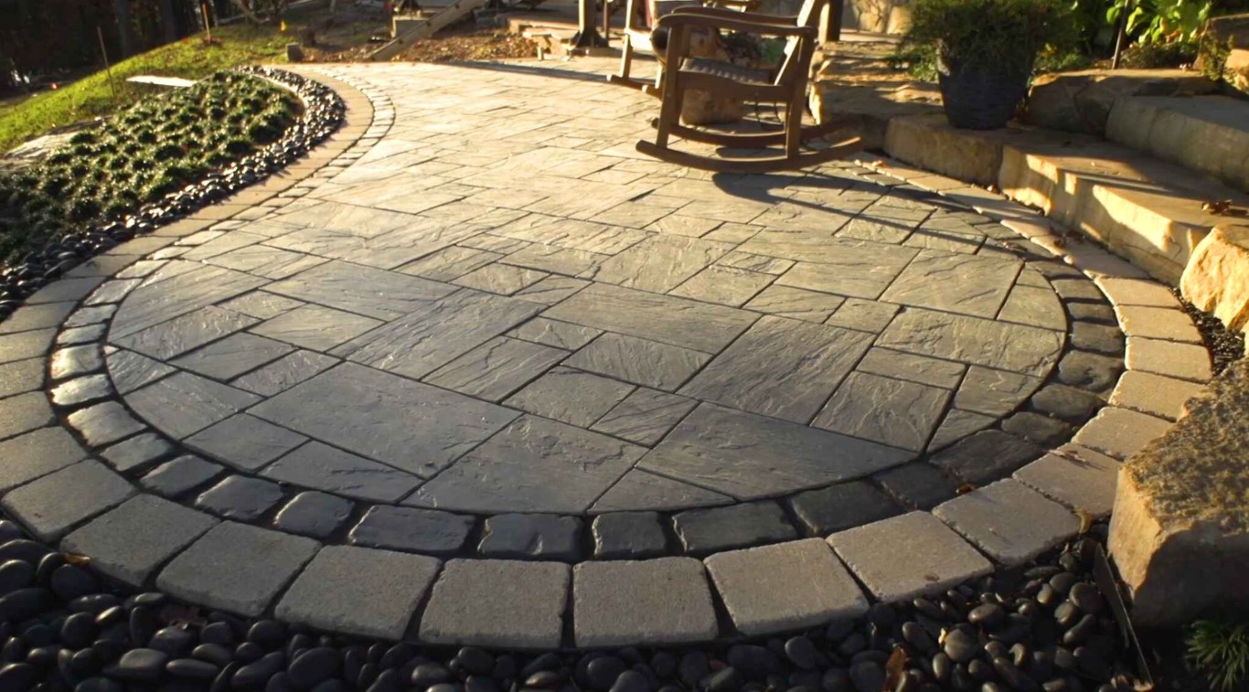 Decorative circular paver patio with stone border hardscaping work