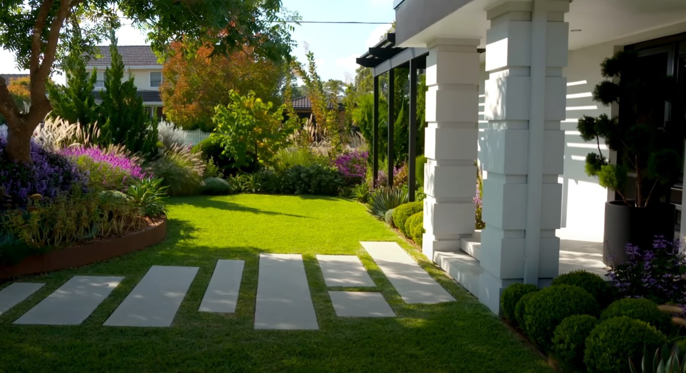 Professional landscape design featuring modern paver walkway through lawn